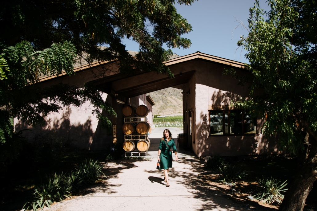 A woman carrying a bottle of wine as she leave Orofino Vineyards in Cawston, BC.