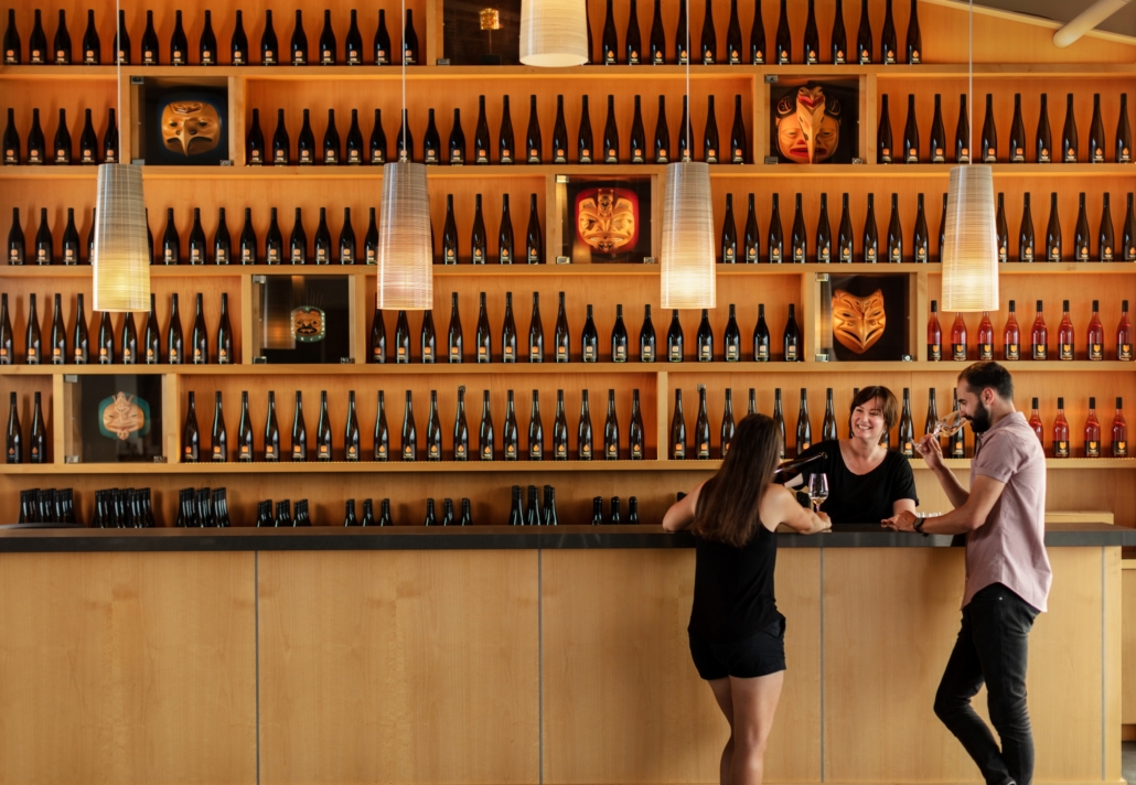 A couple sampling wine at the tasting bar at Tantalus Vineyards in Kelowna,  BC,