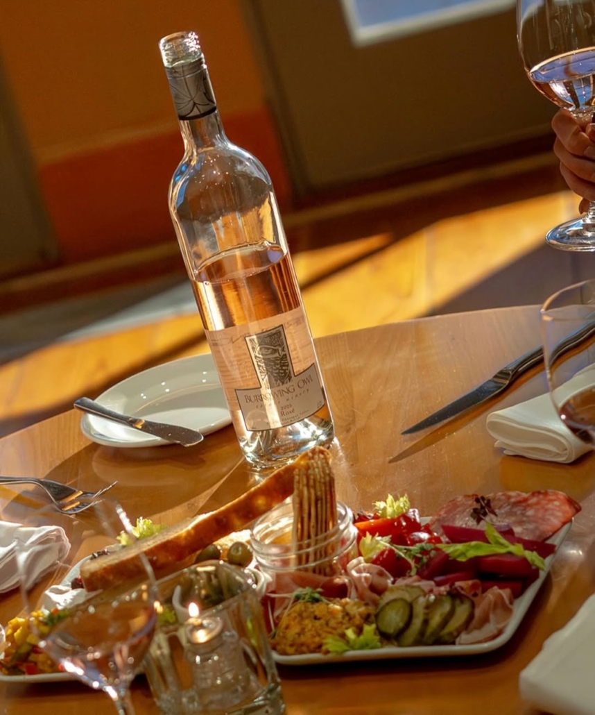 A delicious charcuterie platter with a bottle of Burrowing Owl Rose at The Sonora Room restaurant located a Burrowing Owl Winery in Oliver, BC.
