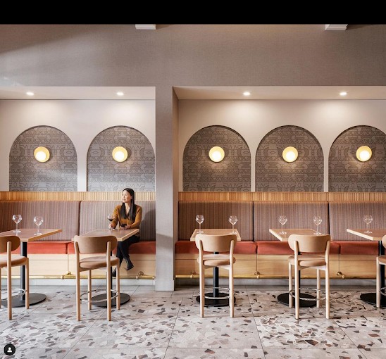 A woman enjoying a glass of wine at the The Bear the Fish, the Root & the Berry restaurant located at Nk'Mip Cellars.