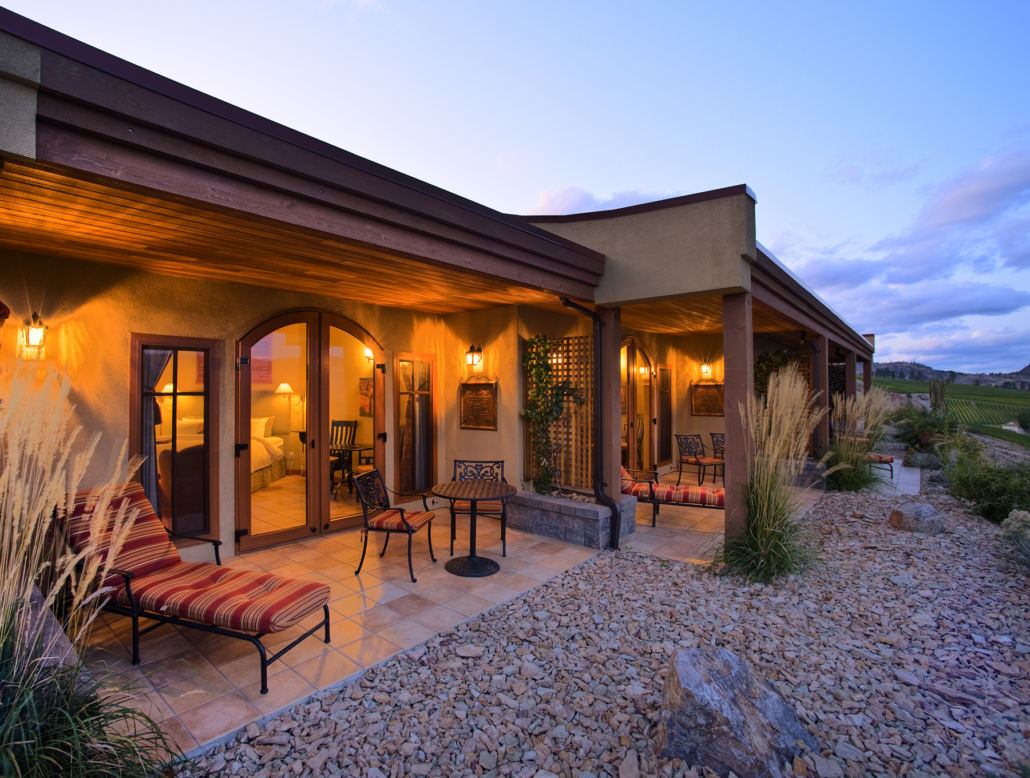The Villas at Hester Creek Estate Winery lit at dusk with vineyard views in the background overlaying the Golden Mile.