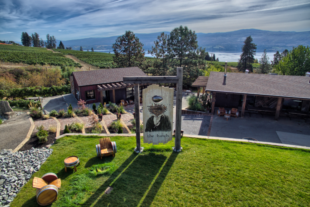 The Hatch Winery on a sunny day with barrel chair out front, located in West Kelowna, BC.