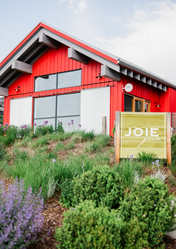 Bright Red Joiee Farm tasting room with blooming flowers out front.