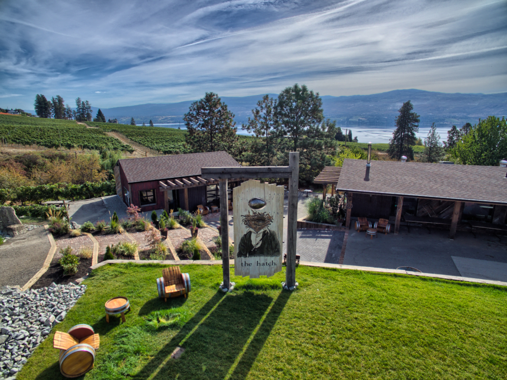 The Hatch Winery on a sunny day with barrel chair out front, located in West Kelowna, BC.