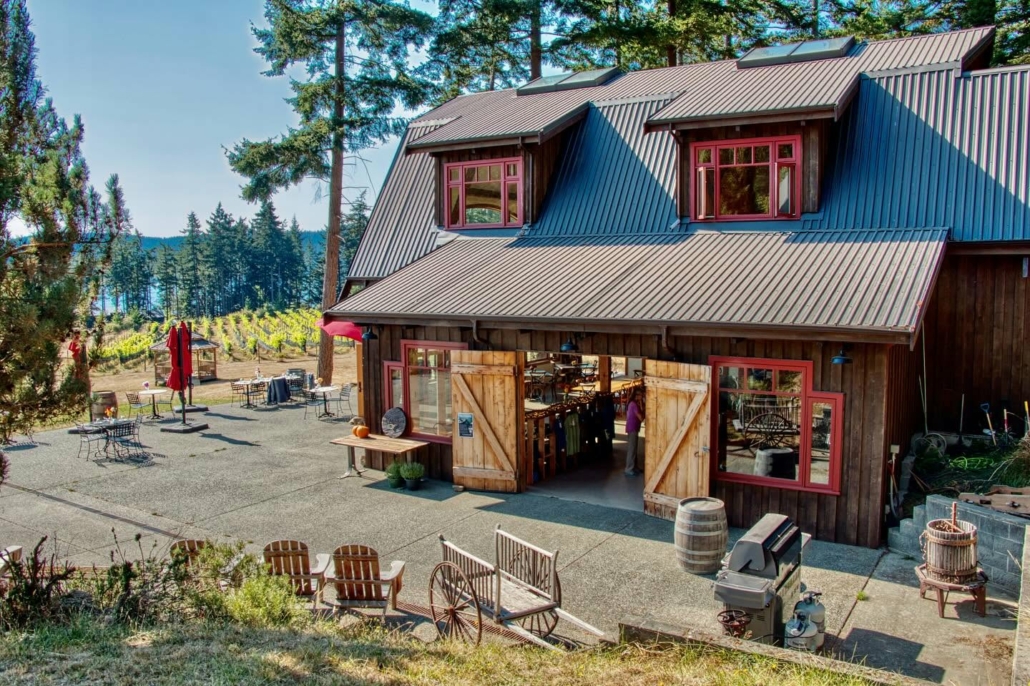 Rustic Sage Hayward Vineyards Winery on Saturna Island on the sunny day with a the view of the vineyard and ocean in the background.